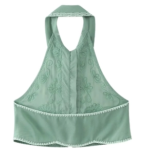 Detailed front view of green halter top featuring floral embroidery and lace trim