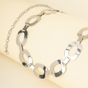 Detailed view of shiny silver metal chain belt with oval links and adjustable clasp
