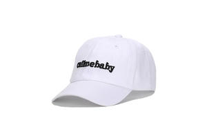 Dettaglio del ricamo nero CALL ME BABY su un cappellino da baseball in cotone bianco