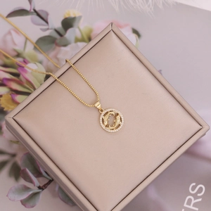 Close-up of gold Pisces zodiac necklace with zircon border on elegant gift box