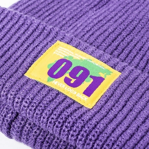 Purple knit beanie with yellow woven patch and urban street style ribbed texture
