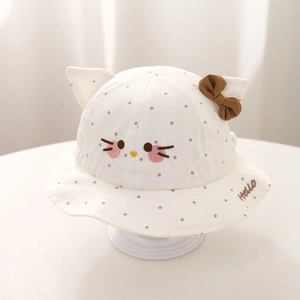 Detail of baby sun hat with cat ears, polka dots, and sweet bow on cotton fabric