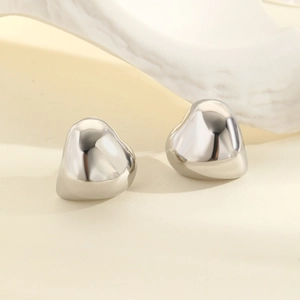Macro shot of silver heart earrings with high polish finish on artistic white stone