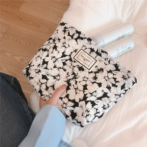 Detail of floral makeup bag holding skincare bottles on a soft lifestyle background
