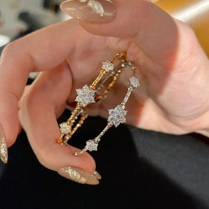Detailed macro view of gold and silver flower bracelets with twisted metal and sparkling zircon