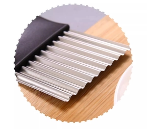 Close-up of stainless steel crinkle cutter blade with ergonomic black handle on wood