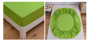 Detail view of bright green fitted sheet with elastic band for a snug mattress fit