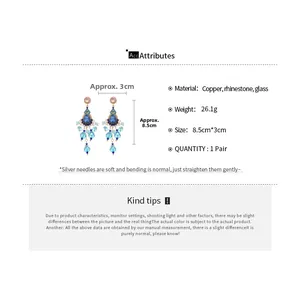 Macro detail of blue crystal drop earrings with crystal tassels and silver pins