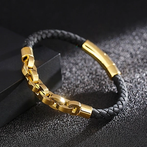 Detail of gold stainless steel chain spliced with black braided leather bracelet