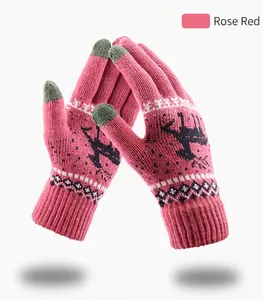 Detail of rose red knitted winter gloves with reindeer jacquard and touchscreen tips