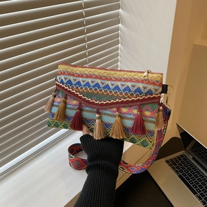 Detail of bohemian woven crossbody bag with colorful fringe tassels and textured patterns