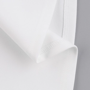 Macro d'une robe en tricot blanc montrant les détails de couture à double aiguille