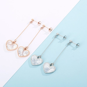 Detailed view of long heart drop earrings in rose gold and silver with marble texture
