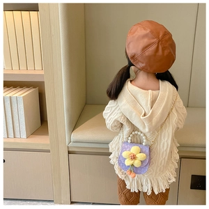 Detail of purple children's bag with yellow flower, pearl handle and metal chain