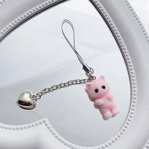 Detail of pink flocked kitten charm with silver heart pendant on a stylish phone strap