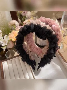 Detail view of sheer organza pleated headbands in black, beige, and dusty pink colors