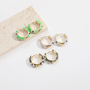 Three pairs of retro evil eye hoop earrings in green, pink, and black enamel finishes