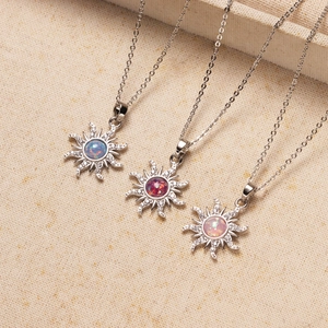 Detalle de primer plano de tres collares de sol con opalo en azul, rojo y rosa con circonitas.