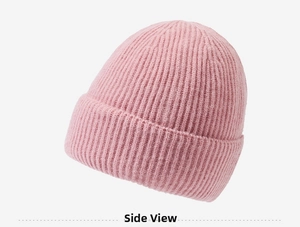 Détail d'un bonnet en tricot rose avec texture à rayures verticales et tissu doux