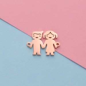 Macro view of rose gold boy and girl charms with dual connection holes for DIY jewelry
