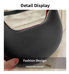 Detail view of black crescent hobo bag with gold zipper and vibrant red lining