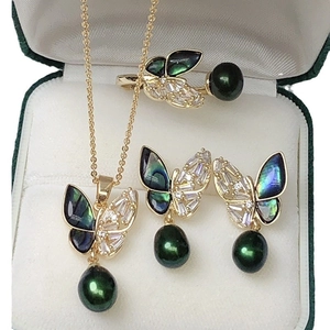 Elegant butterfly jewelry set with dark green pearls and black wings in a white box