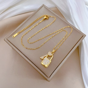 Close-up of gold heart lock and key pendant with clear rhinestones on velvet box