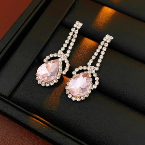 Detailed shot of silver drop earrings with pink water-drop stones in a black jewelry box