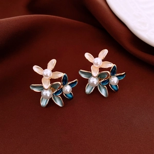 Detailed macro view of 18K gold plated flower earrings with pearls and colorful enamel