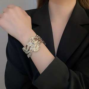 Detailed view of silver wrinkled cuff bracelet with irregular wave texture on model wrist