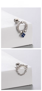 Close-up of titanium steel stud earrings with blue zircon pendants and sparkling stones