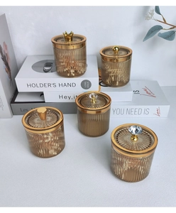 Detailed view of amber striped storage jars with decorative golden crown and ball lids