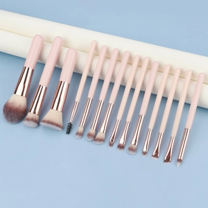 Dettaglio del set di 15 pennelli per il trucco rosa con ghiere in oro rosa su rotolo