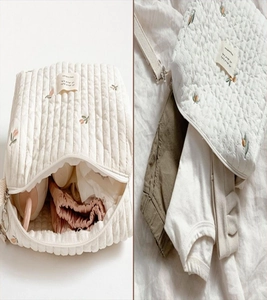 Detail of floral embroidery and quilted cotton texture on this cream nursery organizer bag