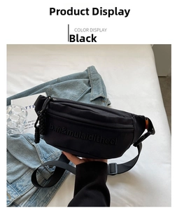 Close-up of black canvas chest bag with embossed lettering and adjustable buckle
