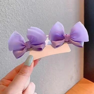 Detail of light purple chiffon bow hair clips for babies on a white display card