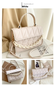 Détail du sac bandoulière blanc matelassé avec chaîne en résine et fermoir doré