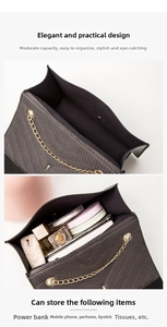 Detail view of black crossbody bag interior capacity with chain strap and items