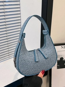 Chic blue woven half-moon shoulder bag with a minimalist aesthetic and sleek zipper