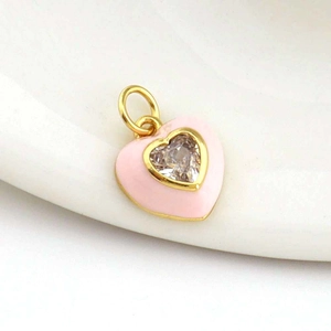 Macro shot of 18k gold plated pink enamel heart pendant with a central heart zircon