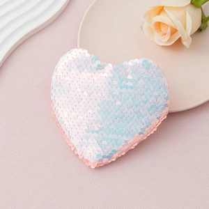 Detail showing the heart shaped sequin bag with iridescent pink and blue gradient shimmer