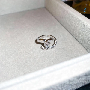 Macro shot of silver ring with double C design paved with white zircons in a jewelry box