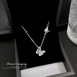 Detailed macro view of silver butterfly pendant necklace in premium black velvet jewelry box