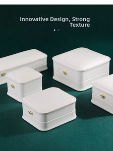 Detailed view of white leather jewelry box set with golden crown buckle and fine texture