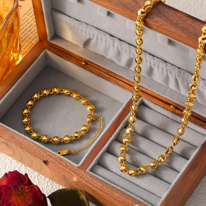 Set di gioielli con catena a sfere dorate, collana e bracciale su velluto vintage