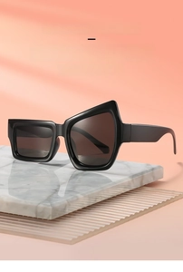 Détail de lunettes de soleil noires irrégulières avec monture géométrique sur marbre