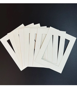 Macro shot of white rectangle photo mat boards stacked on a black textured surface