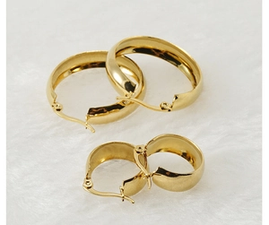 Detailed view of polished 18K gold stainless steel hoop earrings in two sizes on white fur