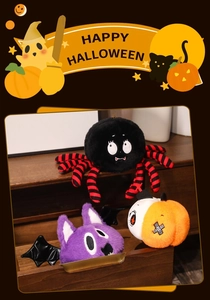 Close-up of Halloween plush set featuring a black spider, purple cat, and orange pumpkin toy