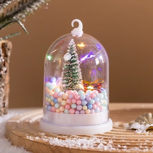 Close-up of a Christmas snow globe night light with a mini tree and colorful LED lights